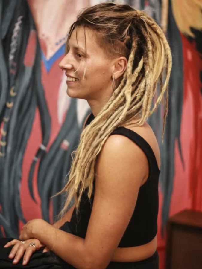Cliente de perfil com rastas longas loiras criadas no Om Rastas